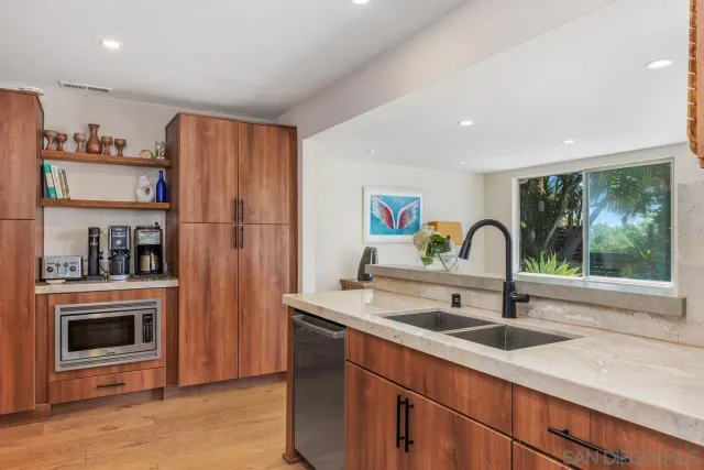 a kitchen with stainless steel appliances a sink and a refrigerator