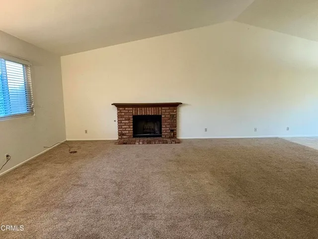 a living room with stainless steel appliances granite countertop furniture and a fireplace
