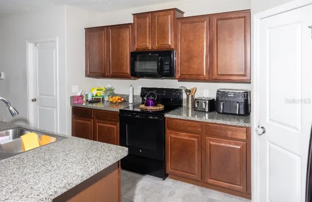 a kitchen with stainless steel appliances granite countertop a sink stove and microwave
