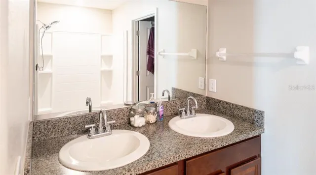 a bathroom with a granite countertop sink and a mirror