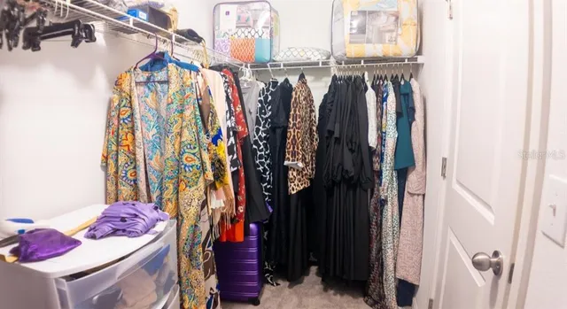 a view of walk in closet with clothes