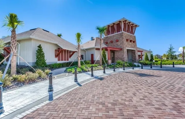 a front view of a house with a yard and potted plants