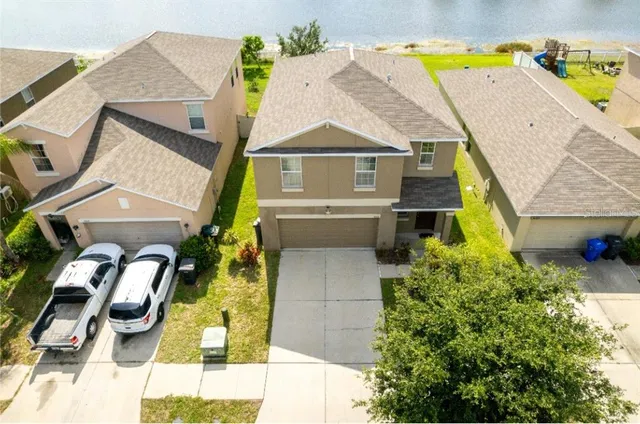 an aerial view of residential houses with yard