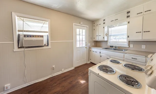 a kitchen with a stove a sink and a window