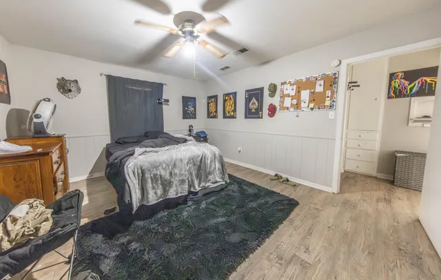 a bedroom with a large bed and a chandelier