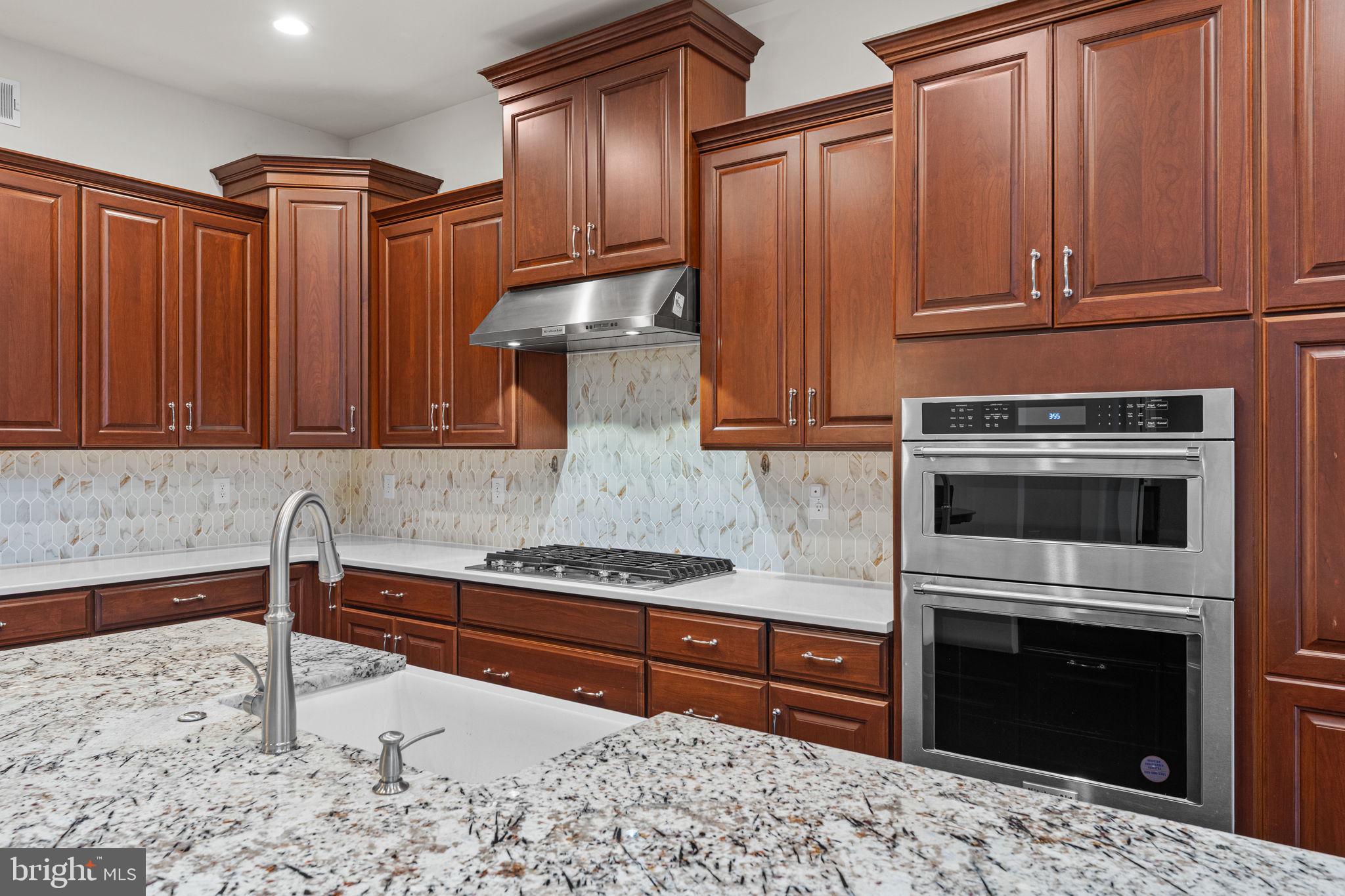 735 Appaloosa Road Downingtown, PA 19335 - Photo 17 of 35 a kitchen with granite countertop wooden cabinets and stainless steel appliances