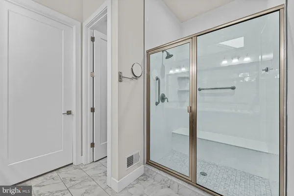 a bathroom with a glass shower door and a glass door