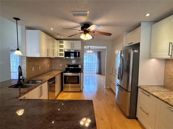 a kitchen with kitchen island a counter top space appliances and cabinets