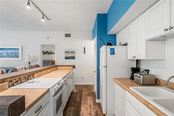a kitchen with a sink stove and refrigerator