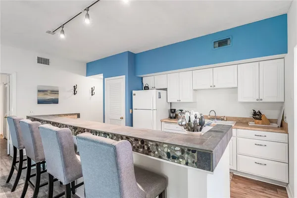 a kitchen with stainless steel appliances granite countertop a white cabinets and a stove