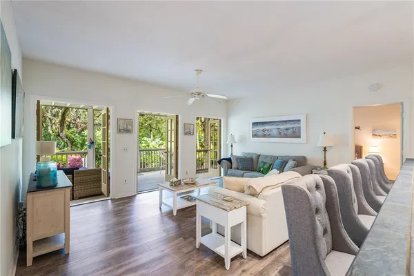 a living room with furniture floor to ceiling window and wooden floor
