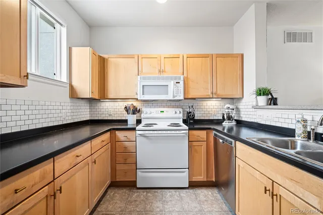 a kitchen with stainless steel appliances granite countertop white cabinets a sink and a stove