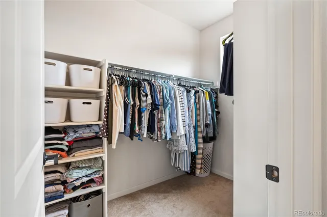 a view of walk in closet with clothes and shoes