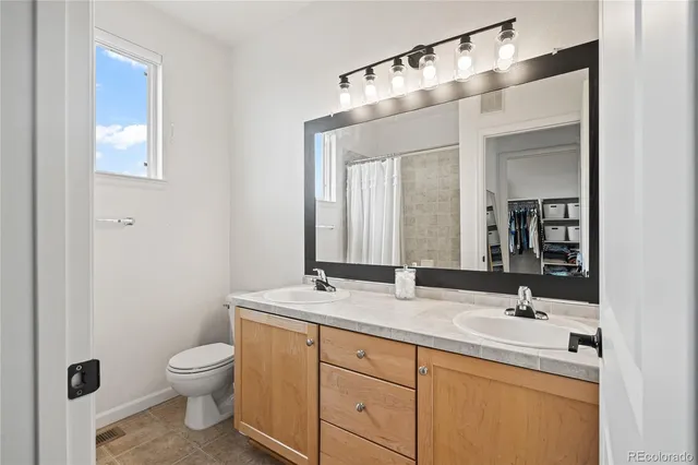 a bathroom with a granite countertop toilet sink and mirror