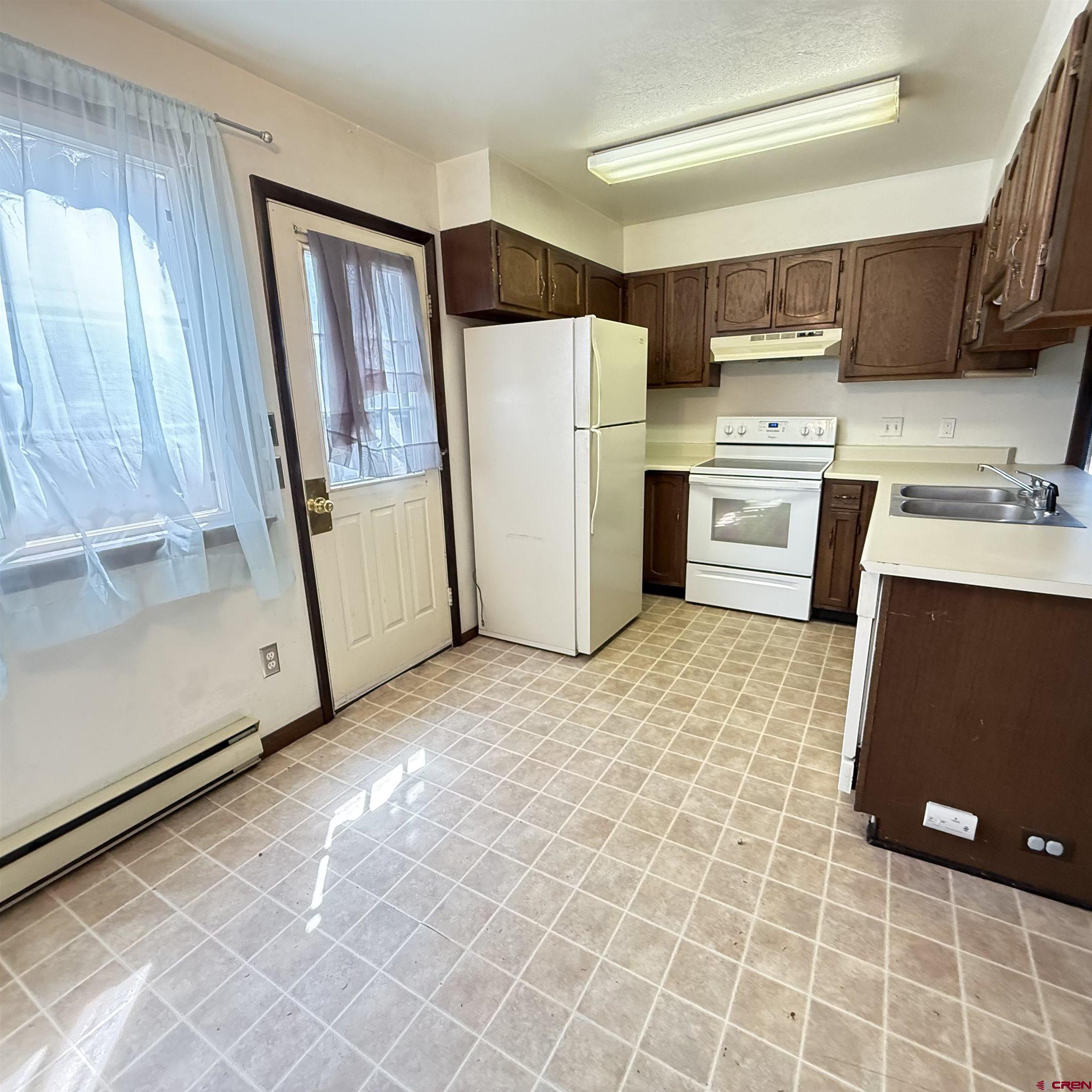 1021 West Denver Avenue, Unit 4 Gunnison, CO 81230 - Photo 13 of 26 a kitchen with refrigerator cabinets and wooden floor