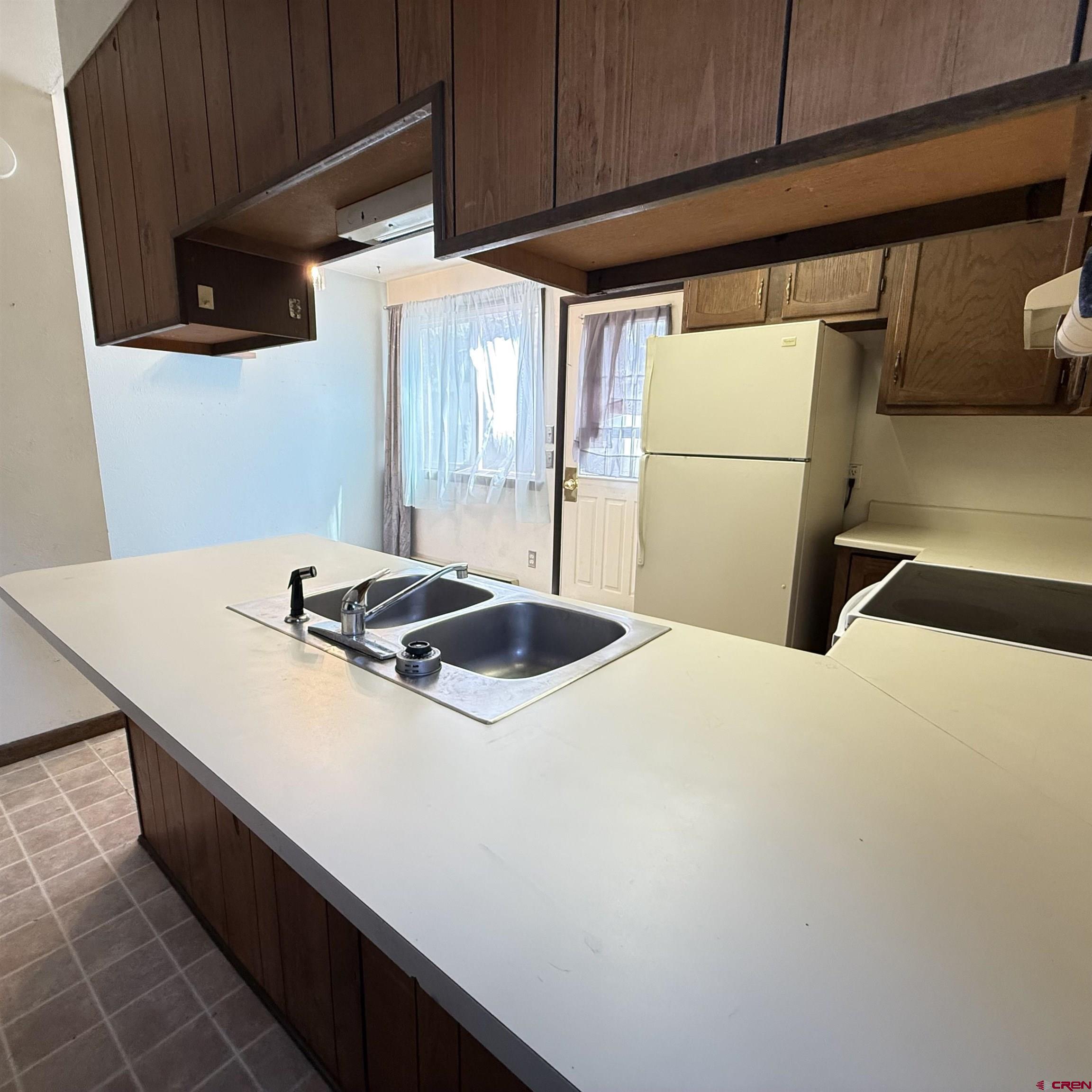 1021 West Denver Avenue, Unit 4 Gunnison, CO 81230 - Photo 16 of 26 a kitchen with a sink a stove and a refrigerator