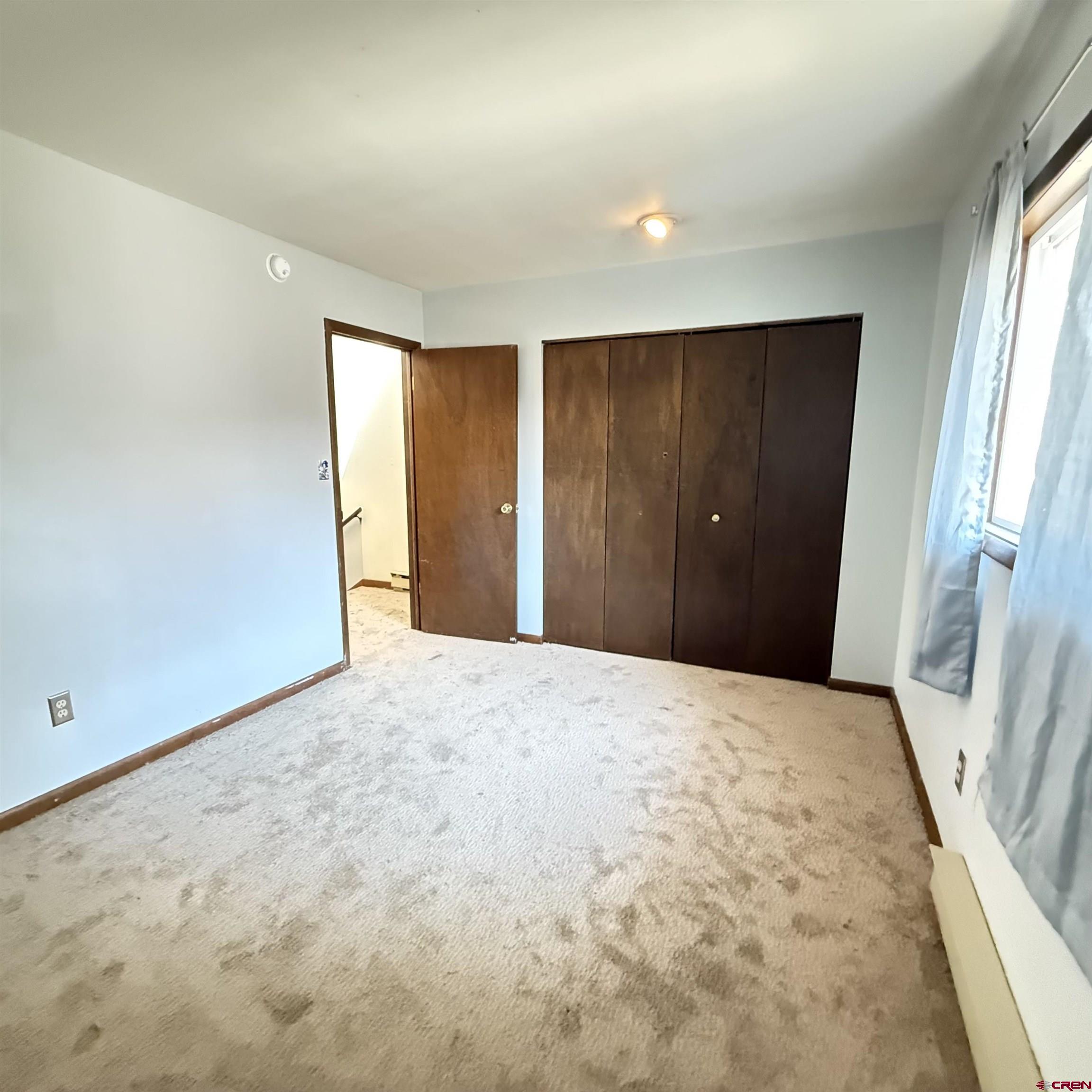 1021 West Denver Avenue, Unit 4 Gunnison, CO 81230 - Photo 24 of 26 an empty room with closet and wooden floor