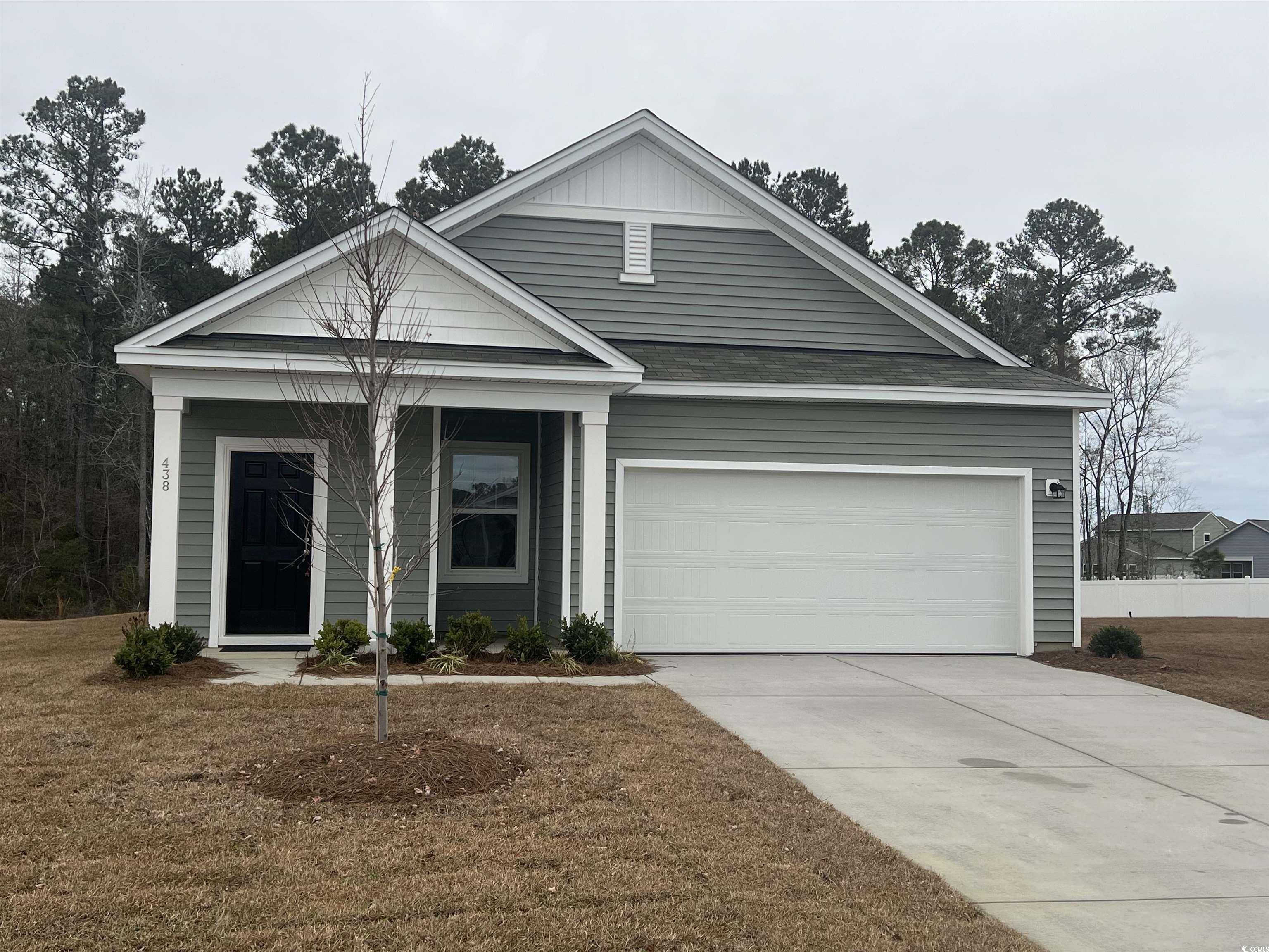 View of front of property with a porch, driveway, and an attached garage