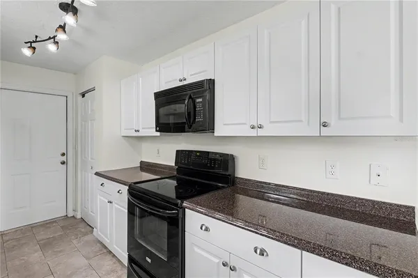 a kitchen with granite countertop a sink stainless steel appliances and cabinets