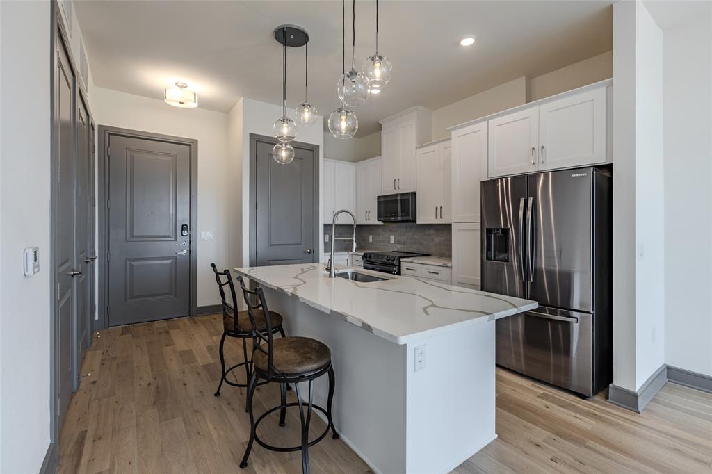 2700 Old Denton Road, Unit 4473 Carrollton, TX 75007 - Photo 4 of 27 a kitchen with kitchen island a sink stove and refrigerator