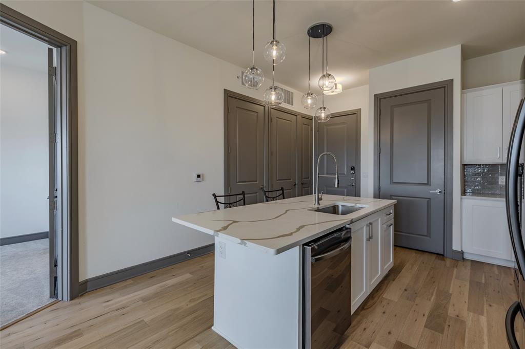 2700 Old Denton Road, Unit 4473 Carrollton, TX 75007 - Photo 6 of 27 a kitchen that has a sink a microwave oven a refrigerator and wooden floor
