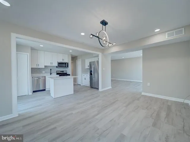 a kitchen with a refrigerator a stove top oven a sink and cabinets
