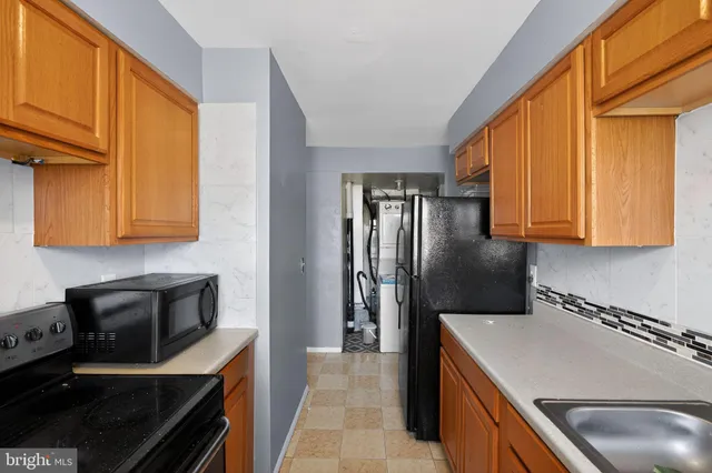 a kitchen with stainless steel appliances granite countertop a refrigerator a stove and a sink