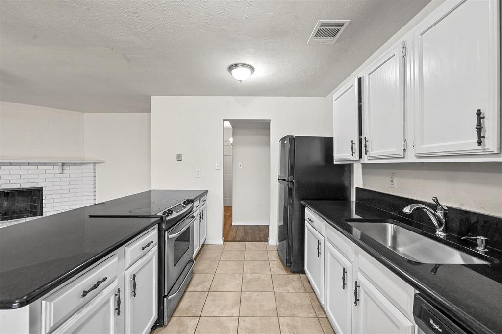 718 Roaming Rd Drive Allen, TX 75002 - Photo 6 of 21 Kitchen featuring electric stove, white cabinetry, dark stone counters, a peninsula, and freestanding refrigerator