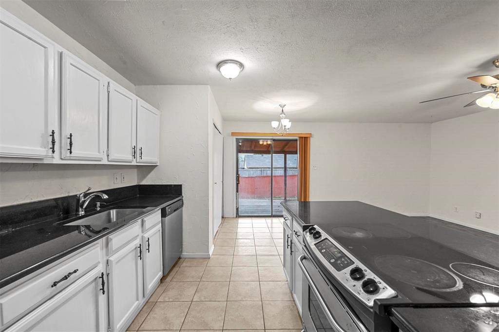 718 Roaming Rd Drive Allen, TX 75002 - Photo 9 of 21 Kitchen featuring stainless steel appliances, white cabinetry, light tile patterned floors, a textured ceiling, and a ceiling fan