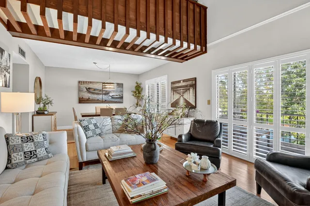 a living room with furniture and floor to ceiling windows