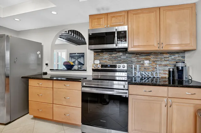 a kitchen with stainless steel appliances a stove microwave and sink