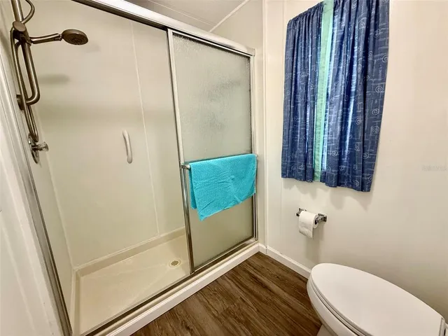 a kitchen with stainless steel appliances a dining table chairs a refrigerator and cabinets