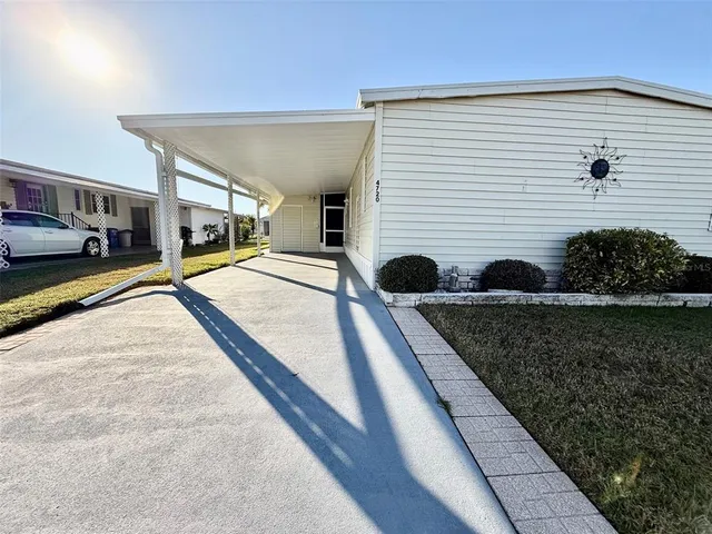 a view of a house with backyard and sitting area