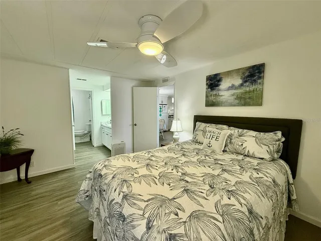 a spacious bedroom with a bed and a chandelier