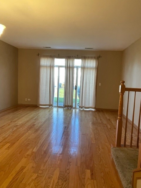 2332 Overlook Court, Unit 2332 Naperville, IL 60563 - Photo 6 of 26 a view of an empty room with wooden floor and a window
