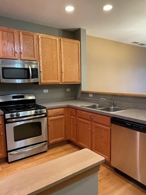 2332 Overlook Court, Unit 2332 Naperville, IL 60563 - Photo 8 of 26 a kitchen with granite countertop wooden cabinets stainless steel appliances and a window