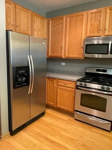 a kitchen with stainless steel appliances granite countertop a stove a microwave and a refrigerator