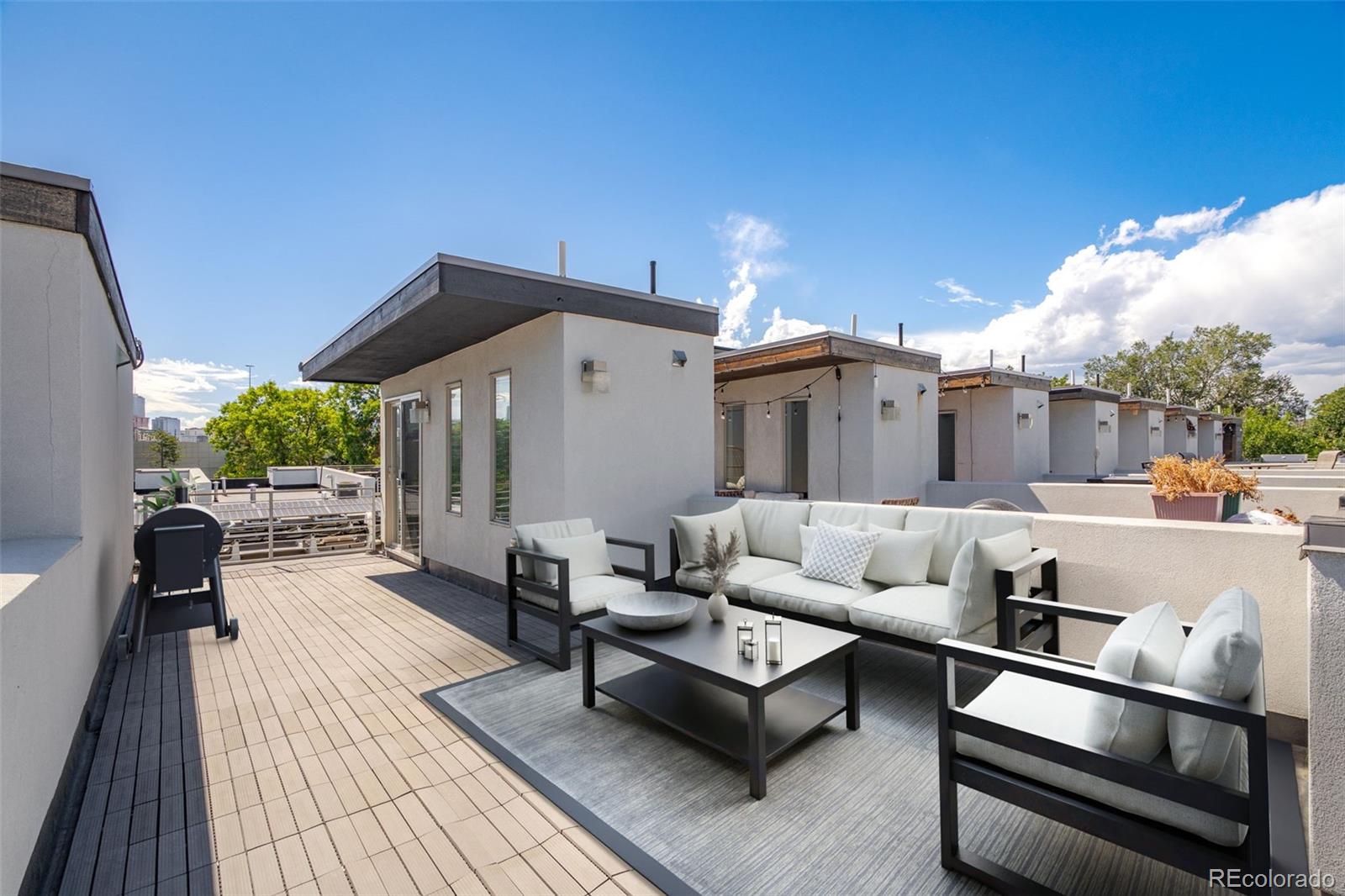 1022 West 37th Avenue Denver, CO 80211 - Photo 14 of 29 a roof deck with couches and potted plants with sky view
