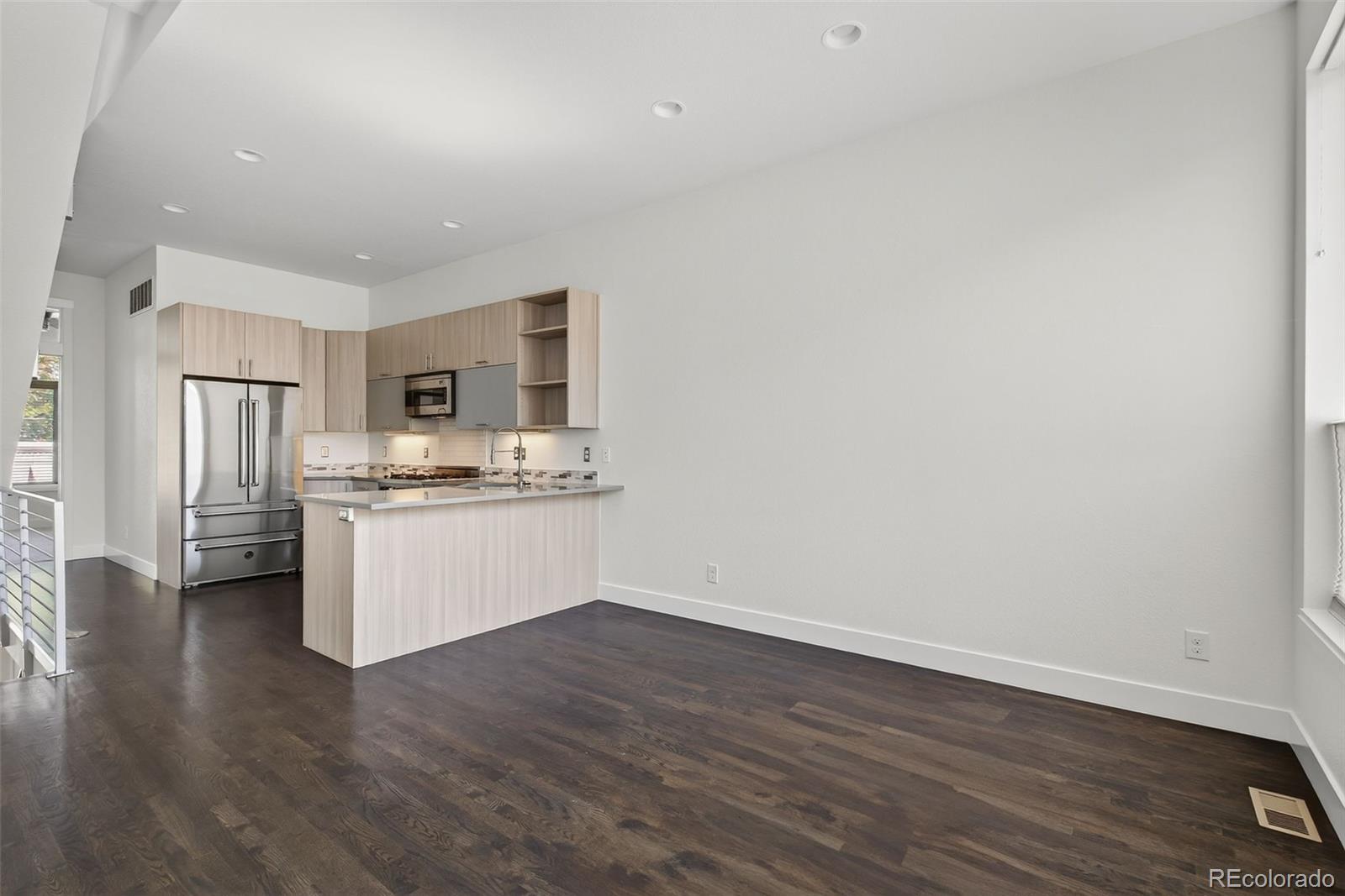 1022 West 37th Avenue Denver, CO 80211 - Photo 19 of 29 a kitchen with stainless steel appliances wooden floor and more cabinets