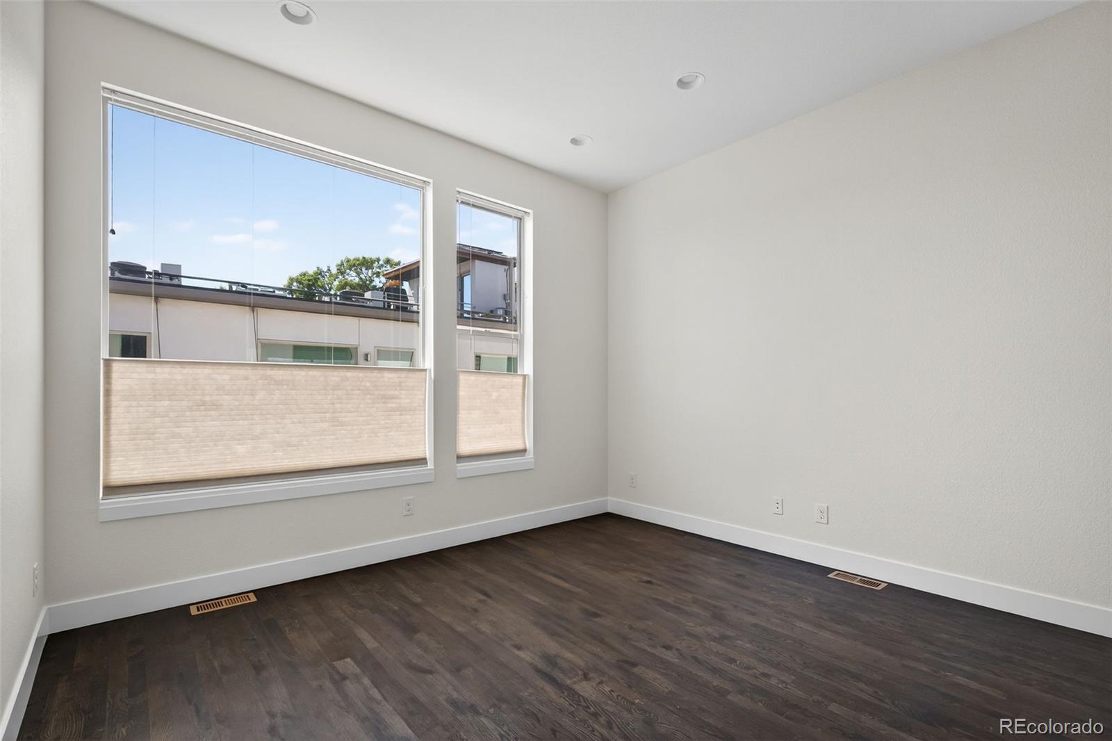 1022 West 37th Avenue Denver, CO 80211 - Photo 21 of 29 an empty room with wooden floor and windows
