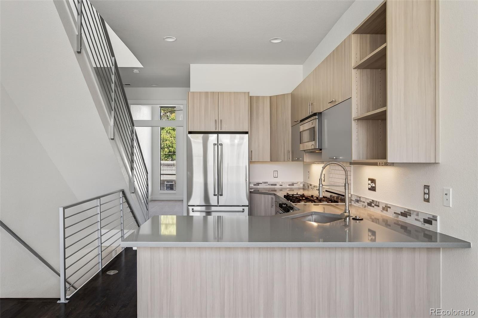 1022 West 37th Avenue Denver, CO 80211 - Photo 4 of 29 a kitchen with stainless steel appliances a sink dishwasher a refrigerator and a stove with wooden floor