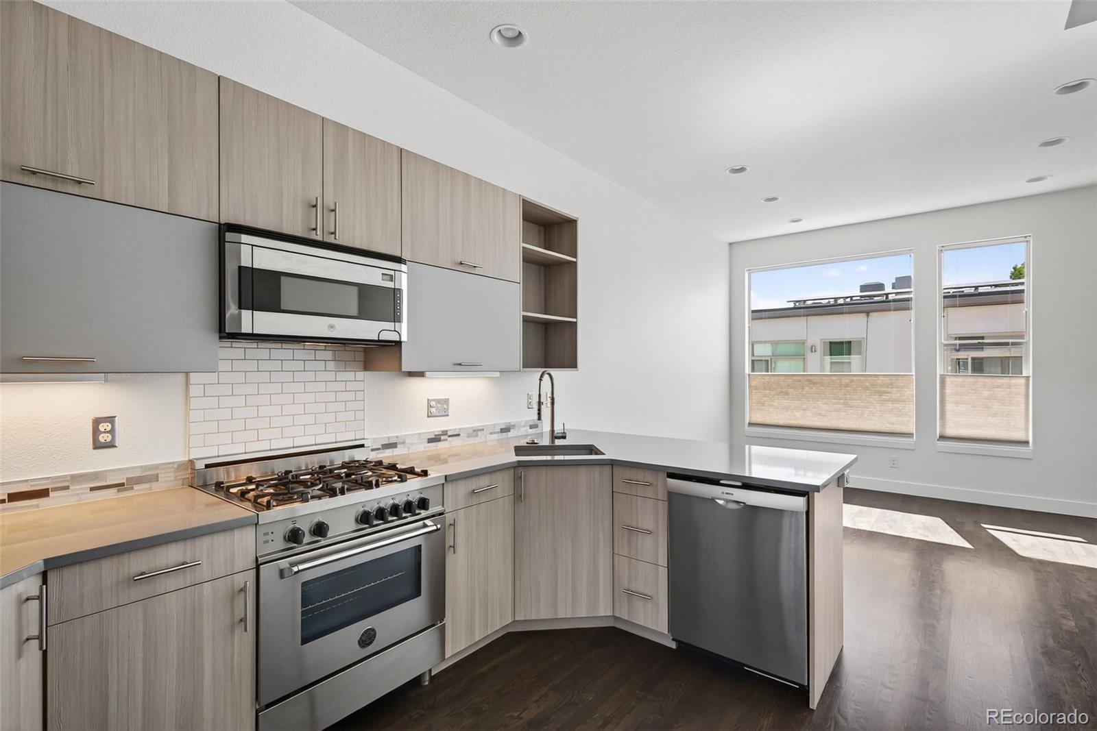 1022 West 37th Avenue Denver, CO 80211 - Photo 5 of 29 a kitchen with stainless steel appliances a stove sink and microwave
