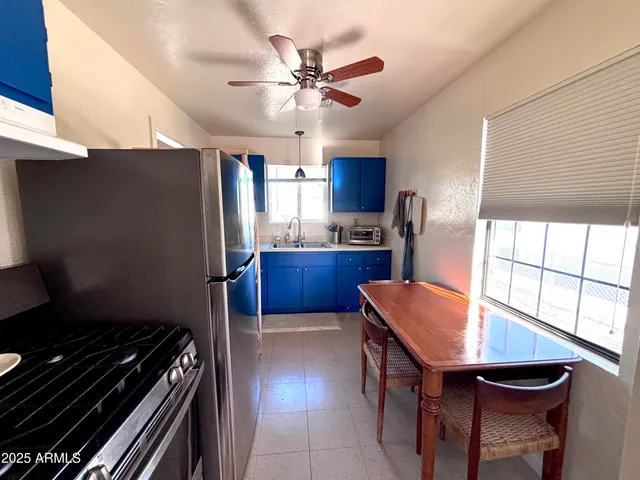 a kitchen with stainless steel appliances kitchen island hardwood floor stove sink and window