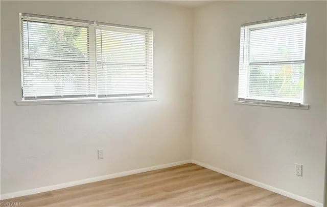 an empty room with a wooden floor and white walls
