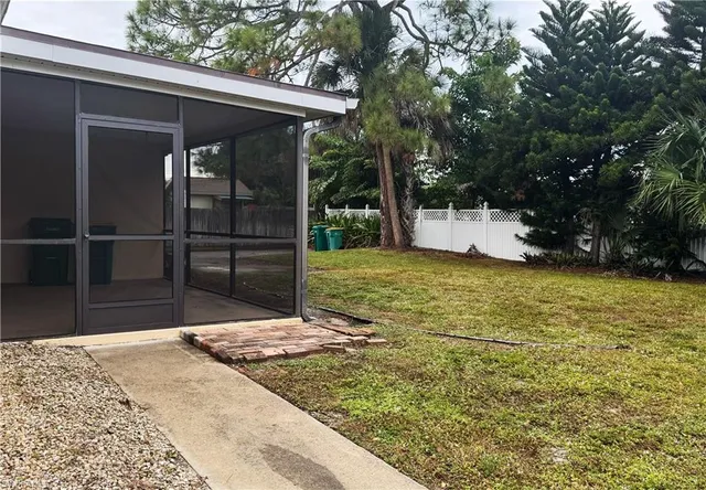 a view of a yard with wooden fence