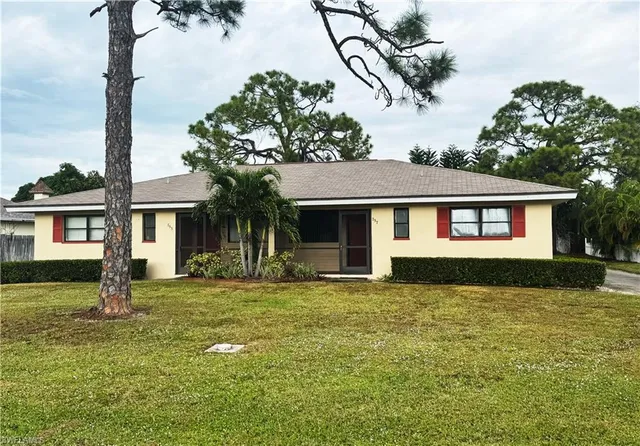 a front view of a house with a garden and yard