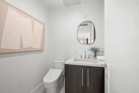 a living room with furniture white walls and a potted plant