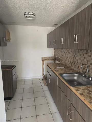 a kitchen with a sink a stove and cabinets