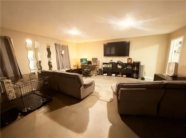 a living room with furniture a flat screen tv and a window