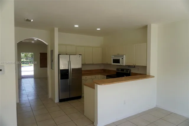 a kitchen with stainless steel appliances a refrigerator and a stove top oven